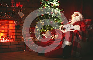 Merry Christmas! santa claus near the fireplace and tree with gi