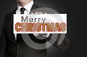 Merry Christmas sign held by businessman concept