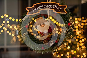 Merry Christmas sign with Santa Claus Hanging doll on a wreath