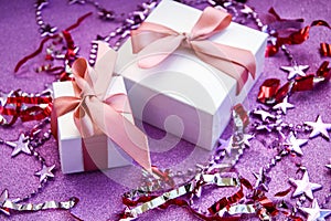 Merry Christmas or St Valentines Day card made of decorations, white gift boxes with pink ribbon, sparkles and confetti