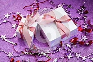 Merry Christmas or St Valentines Day card made of decorations, white gift boxes with pink ribbon, sparkles and confetti