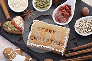 Merry christmas text baked in gingerbread biscuit with white icing