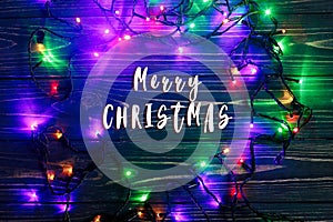 Merry christmas text sign on frame of garland lights. colorful