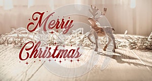 Merry christmas text sign on reindeer ornaments with greeting card and on rustic wooden background. seasonal greetings concept