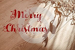 Merry christmas text sign on reindeer ornaments with greeting card and on rustic wooden background. seasonal greetings concept