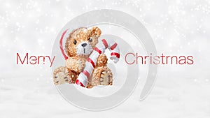 Merry Christmas text and teddy bear with red hat and candy striped cane stick isolated on snowing background, white Christmas