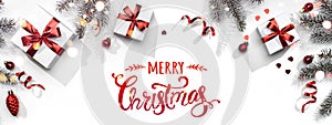 Merry Christmas text on white background with gift boxes, ribbons, red decoration, fir branches, bokeh, sparkles and confetti.