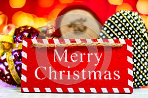 Merry Christmas text wooden sign, decorations and ornaments in a colorful Christmas composition