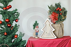 Merry Christmas text on wooden tree decoration with Nutcracker doll