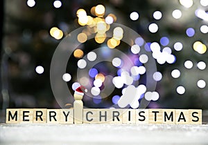 Merry Christmas text written with bokeh cbackground of Christmas tree in the snow, copy space, Holiday, Santa and xmas