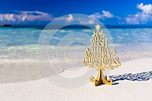 Merry Christmas tree and wishing decoration, in a beach