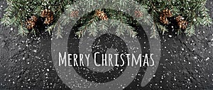Merry Christmas Typographical on dark holiday background with frame of Fir branches, pine cones