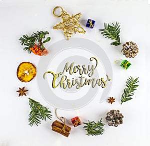 MERRY CHRISTMAS TYPOGRAPHY. FIR BRANCH AND CHRISTMAS DECOR ORNAMENT IN CIRCLE