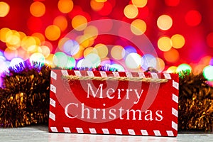 Merry Christmas wooden sign. Christmas composition on blurred lights background