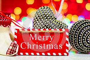 Merry Christmas wooden sign. Christmas composition on blurred lights background. Colorful Christmas balls