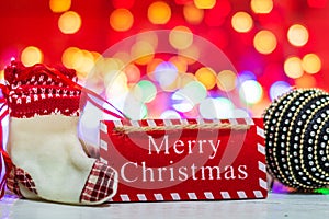 Merry Christmas wooden sign. Christmas composition on blurred lights background. Colorful Christmas balls
