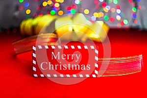 Merry Christmas wooden sign in front of red festive ribbon