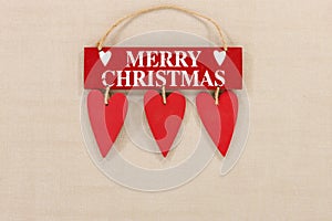 Merry Christmas wooden sign on a pale textured background with space for copy