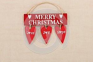 Merry Christmas wooden sign on a pale textured background with space for copy