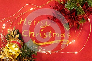 Merry Christmas written with gold acrylic paint on red background.