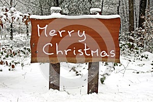 Merry Christmas written on a snowy wooden sign