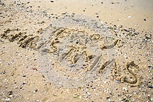 Merry Christmas written on tropical beach sand, copy space.