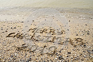 Merry Christmas written on tropical beach sand, copy space. Holiday concept