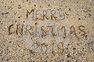 Merry Christmas written on tropical beach sand, copy space. Holiday concept, top view