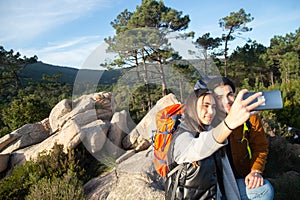 Merry couple of hikers taking selfie