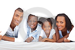 Veselý rodina zabávajúci sa ležiace dole na posteľ 