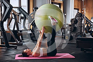 Merry fit woman doing pilates in gym