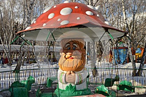 Merry-go-round in the form of mushroom of the old grandfather in the Park of attractions covered with snow