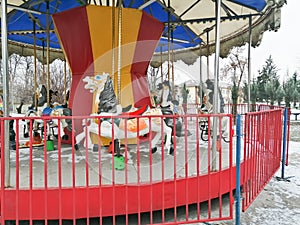 Merry-go-round. A small merry-go-round of children with horses. Bright horses on the carousel in the park.