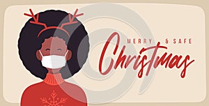 Merry and safe Christmas. African Woman in deer antlers hat wearing protective face mask against coronavirus. Christmas during