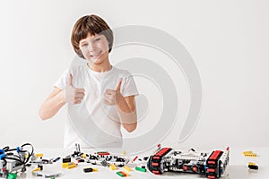 Merry smiling male kid showing ok sign