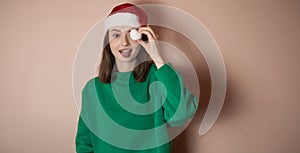 Merry surprised young woman wear xmas sweater Santa hat posing pointing hands arms aside indicate on workspace area isolated on