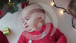 Merry xmas and happy new year, infant, childhood, holidays concept - close-up 6 month old newborn baby in santa claus hat and red