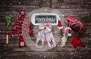 Merry xmas text on wooden sign with classic red christmas decoration on wood.