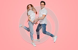 Merry young couple jumping together