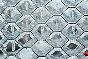 Mesh chain-link, which is very icy in winter. The honeycomb texture is completely covered in icicles.