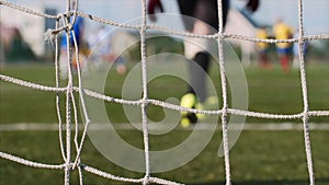 Mesh in football field with blurry soccer players play and training soccer game.