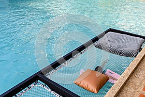 Mesh seat with pillows jut out on swimming pool