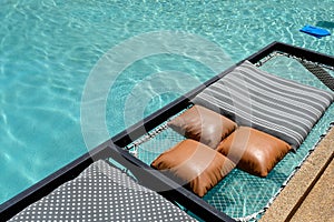 Mesh seat with pillows jut out on swimming pool