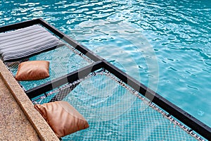 Mesh seat with pillows jut out on swimming pool