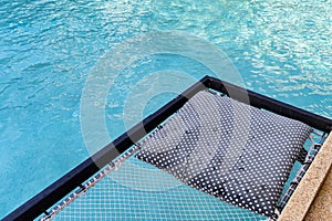 Mesh seat with pillows jut out on swimming pool photo