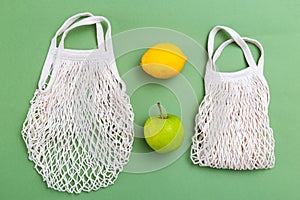 Mesh shopping bag with fruits on green canvas background. reusable concept. BACK TO NATURE