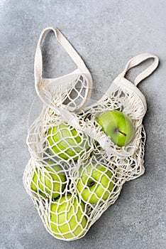 Mesh shopping bag with green apples