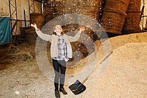 Mesmerised ginger girl throwing wood shavings up and watching them fall