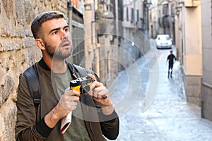 Mesmerized man holding a vintage camera during trip looking a something impressive