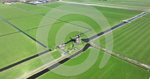 A mesmerizing aerial view of a row of windmills standing tall in the picturesque Dutch landscape.